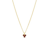 Gold necklace with a small triangle red garnet pendant on a white background