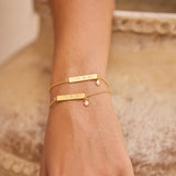 Gold bracelets on a hand with a blurred background