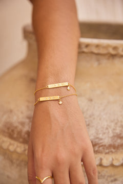 Gold bracelets on a hand with a blurred background