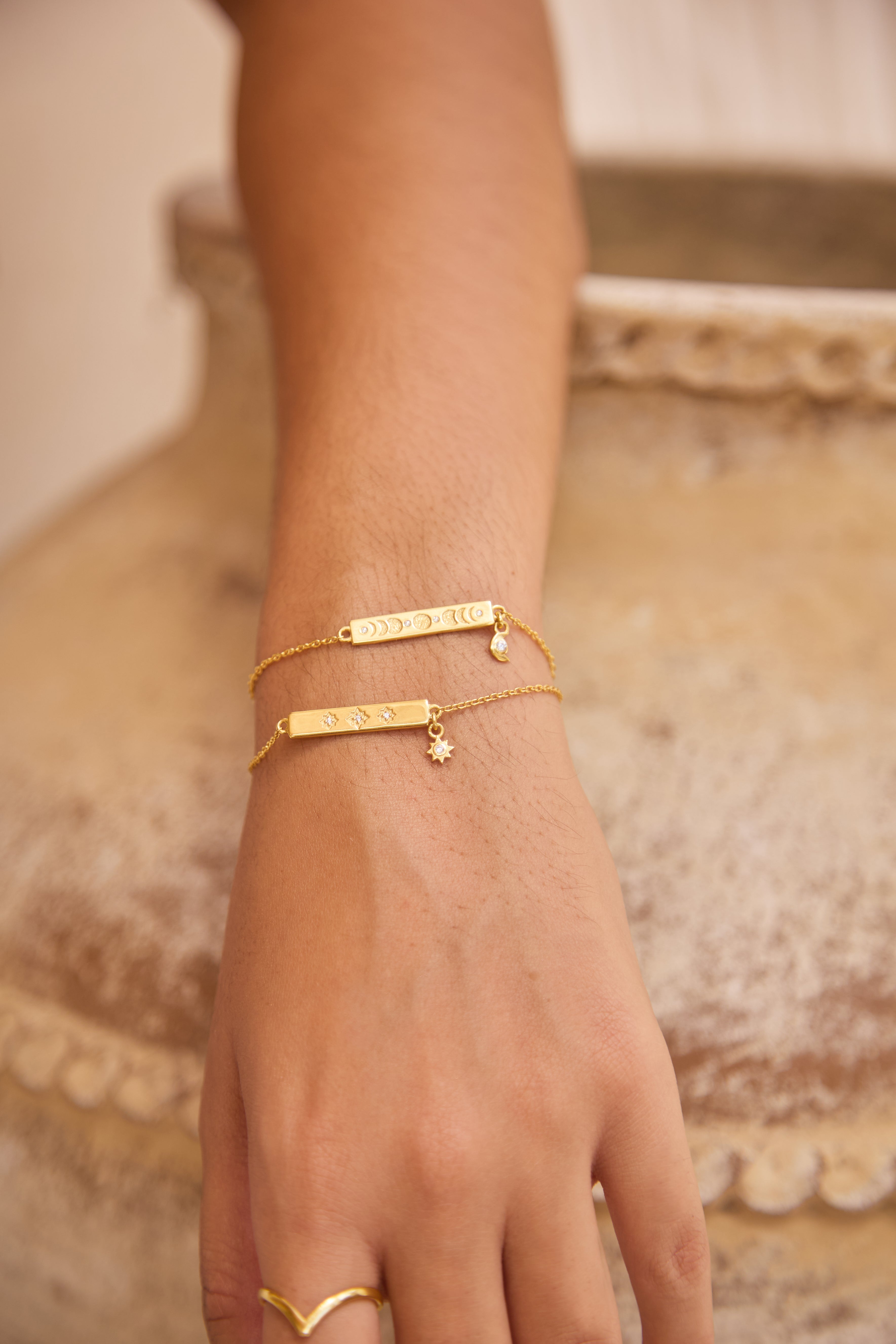 Gold bracelets on a hand with a blurred background