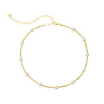 Gold chain choker necklace with bezel set clear stones on a white background