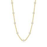 Gold necklace with bezel set clear stones on a white background