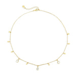 Gold necklace with teardrop-shaped clear stone pendants on a white background