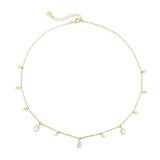 Gold necklace with teardrop-shaped clear stone pendants on a white background