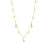 Gold necklace with teardrop-shaped clear stone pendants on a white background