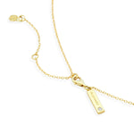 Gold necklace with a bar pendant on a white background