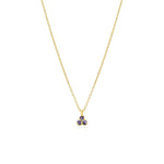 Gold necklace with a small blue purple gemstone triangle pendant on a white background