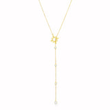 Gold necklace with star and clear stone pendant on a white background