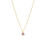 Gold necklace with a small pink triangle gemstone pendant on a white background