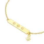 Gold bar bracelet with star-shaped symbols and charm on a white background