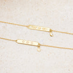 Gold bracelets with engraved designs on a beige stone background