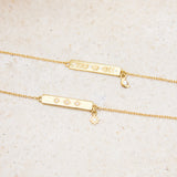 Gold bracelets with engraved designs on a beige stone background